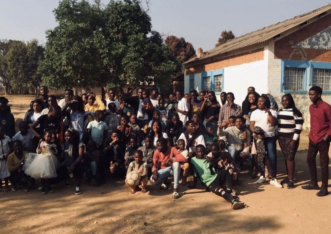 A large group of children and young people from the AILE Foundation community in the DRC
